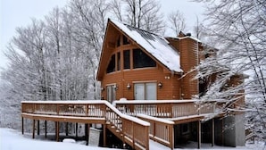 A wooden cabin with a balcony and a staircase leading to the entrance. - NF31-Slopeside Home! Hot Tub! A/C, Fire Pit! (Davis)