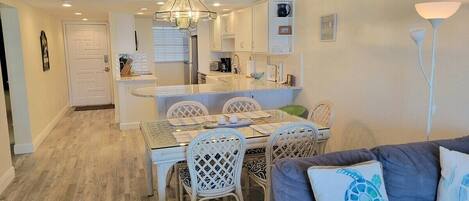 Un espacio habitable compacto con comedor, kitchenette y zona de estar.