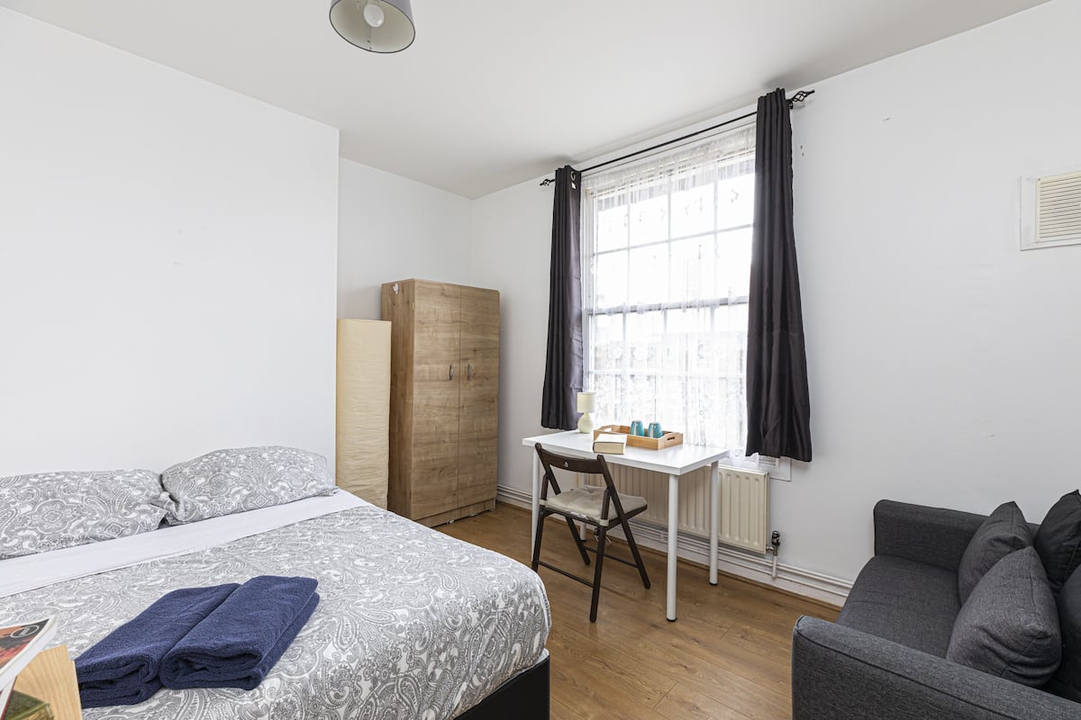 Desk, laptop workspace, iron/ironing board, bed sheets