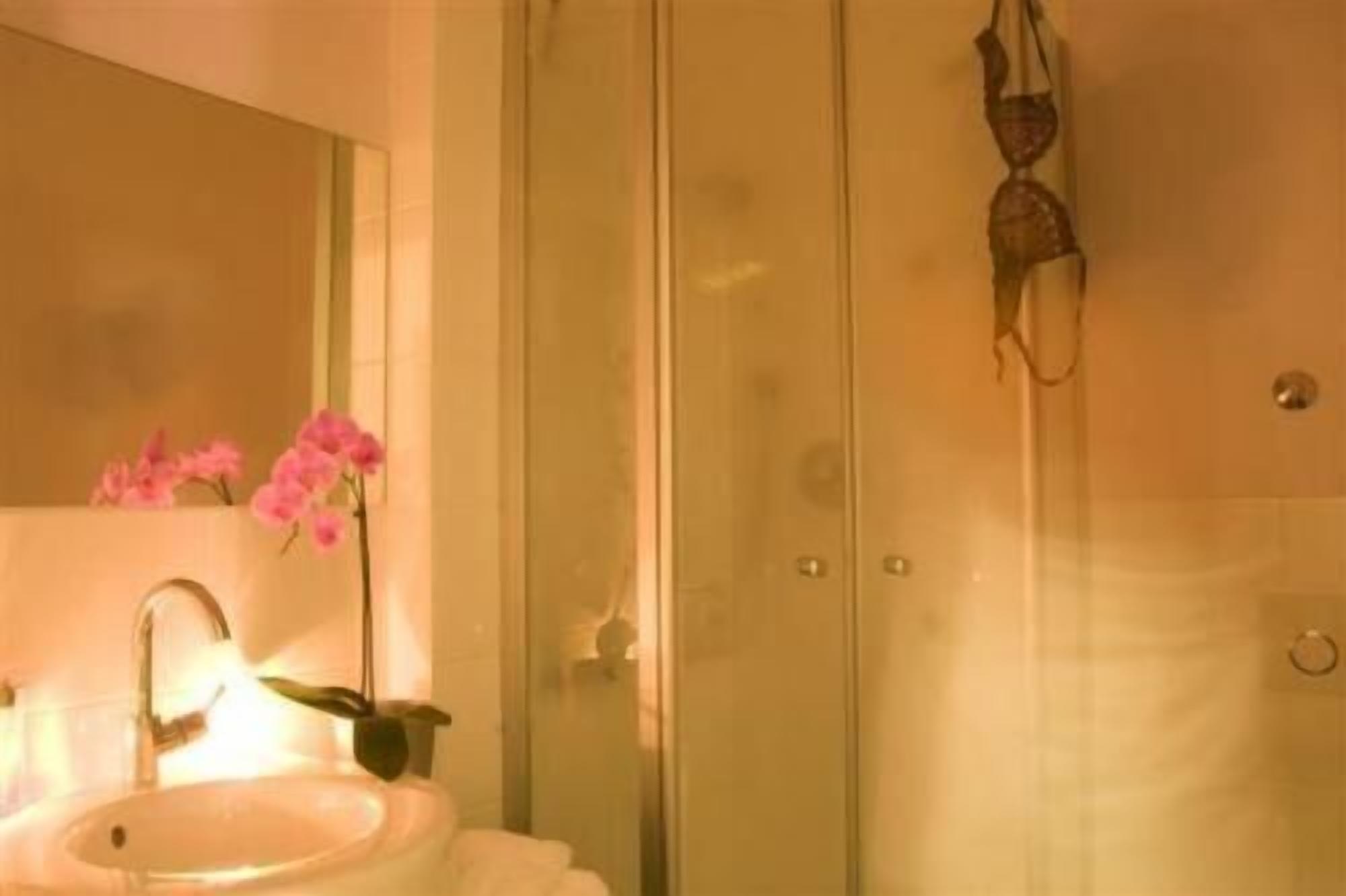 Ein Badezimmer mit Waschbecken, Spiegel und Duschbereich.