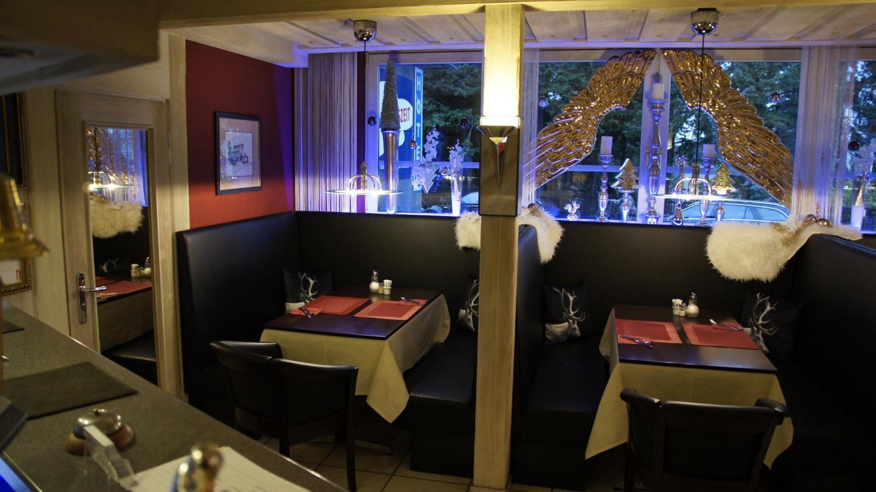 Un restaurant avec des banquettes, un bar et une vue sur l’extérieur.