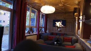 Una sala de estar acogedora con un televisor grande, asientos cómodos y una chimenea.