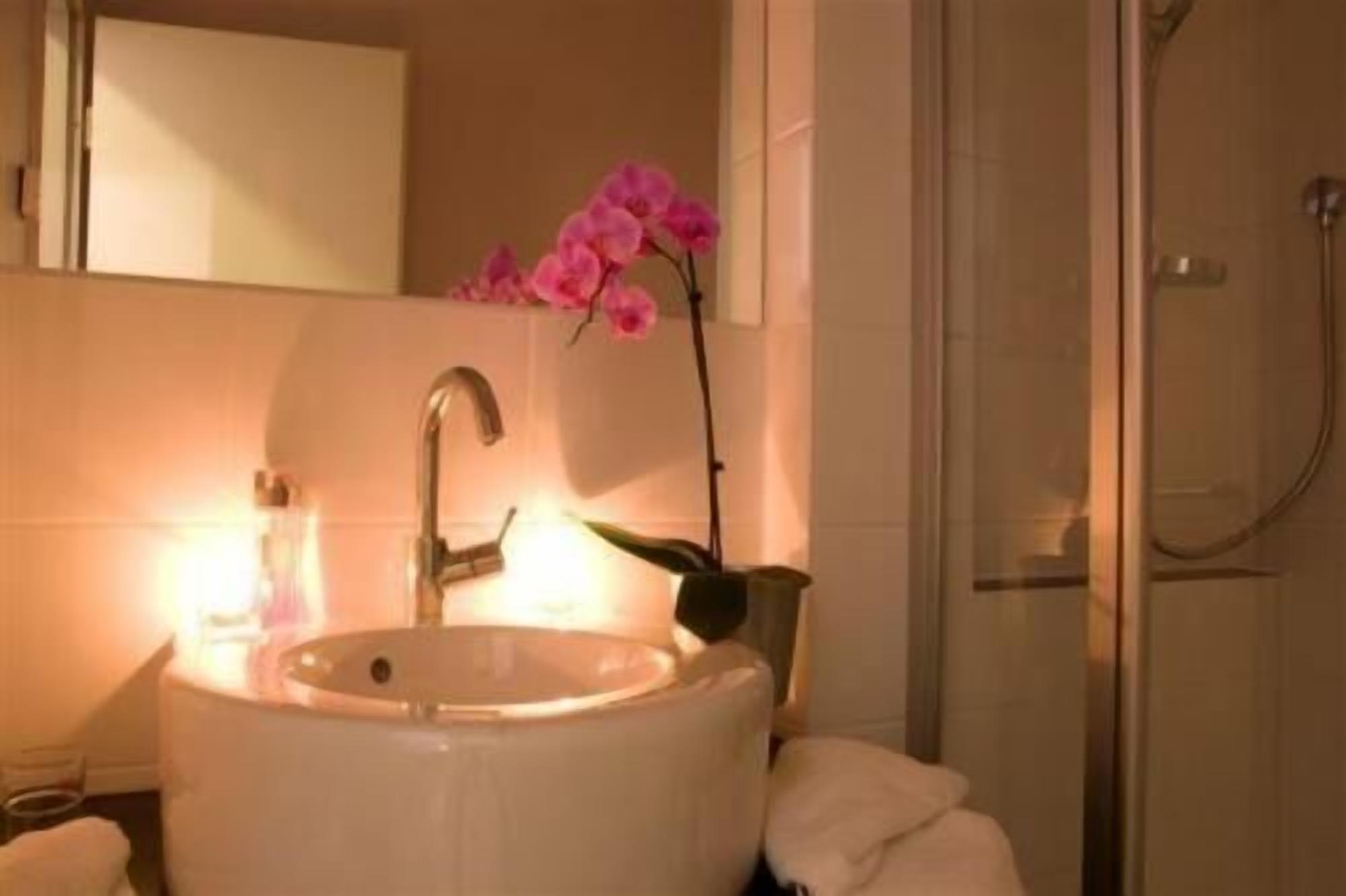Baño con lavamanos, espejo y ducha.