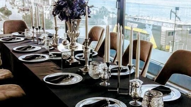 A dining table set for six with a view of the city and sea. - Otel 1919 (Atakum)