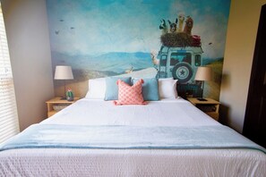 A bed with a white duvet, multiple pillows, and a cactus on a bedside table. - Mosaic South End - 1402 (Charlotte)