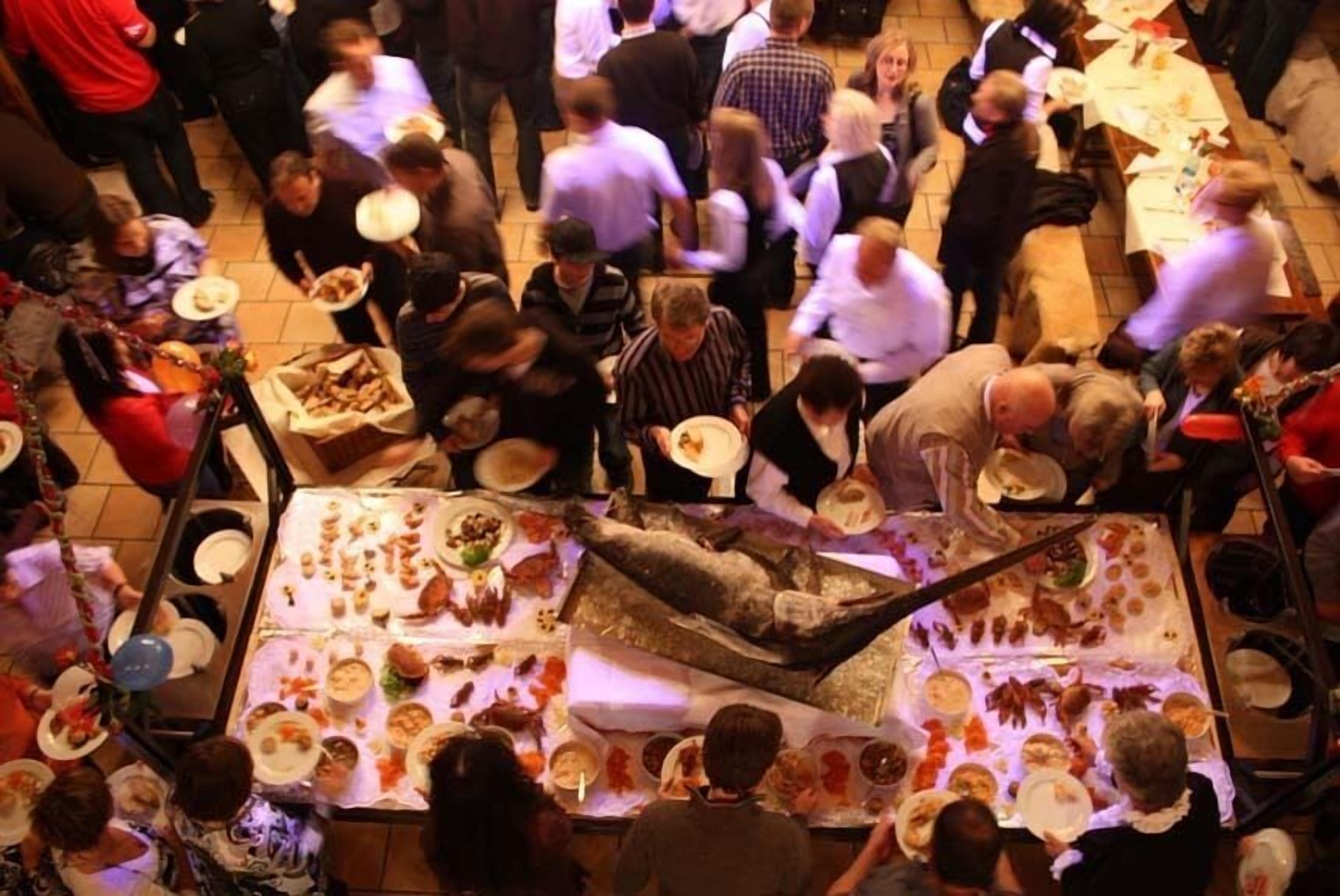 Una sala da pranzo affollata con diversi tavoli e persone impegnate in conversazioni.