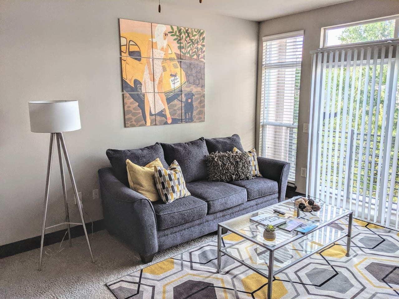 A living room with a sofa, coffee table, and a floor lamp.