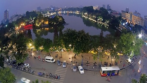 A roundabout with a central park area, surrounded by buildings and a river. - Dollar Homestay & Travel (Hanoi)