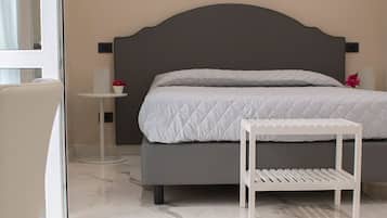 A bedroom with a bed, a bedside table, and a chair.