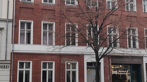 A red brick building with white trim, multiple windows, and a bicycle parked outside. - Altstadt Pension Potsdam (Potsdam)