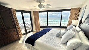 Un dormitorio con una cama grande, ventilador de techo y vista al océano.
