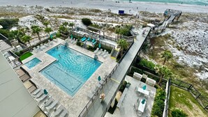 Un resort con piscina, zona de estar al aire libre y vistas a la playa.
