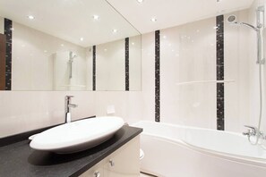 A modern bathroom with a large mirror, a bathtub, and a sink. - SEA VIEW 3 beds next to Palais (Cannes)