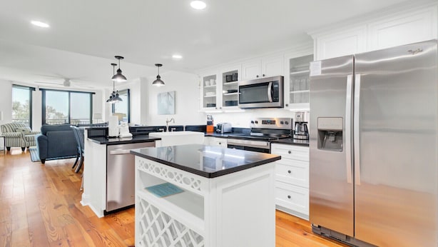 A modern kitchen with white cabinetry, stainless steel appliances, and a central island. - 314 C Shipwatch by AvantStay | OCEANFRONT WITH OCEAN VIEW (Isle Of Palms)