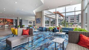 A spacious lobby with modern seating, large windows, and a visible restaurant area. - Cambria Hotel Nashville Airport (Nashville)