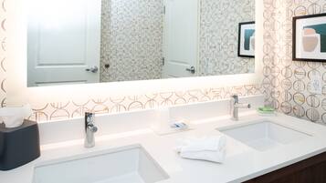 A bathroom with two sinks, a mirror, and a towel rack.