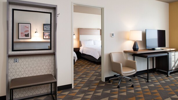 Een hotelkamer met een bed, bureau, stoel en een bank.