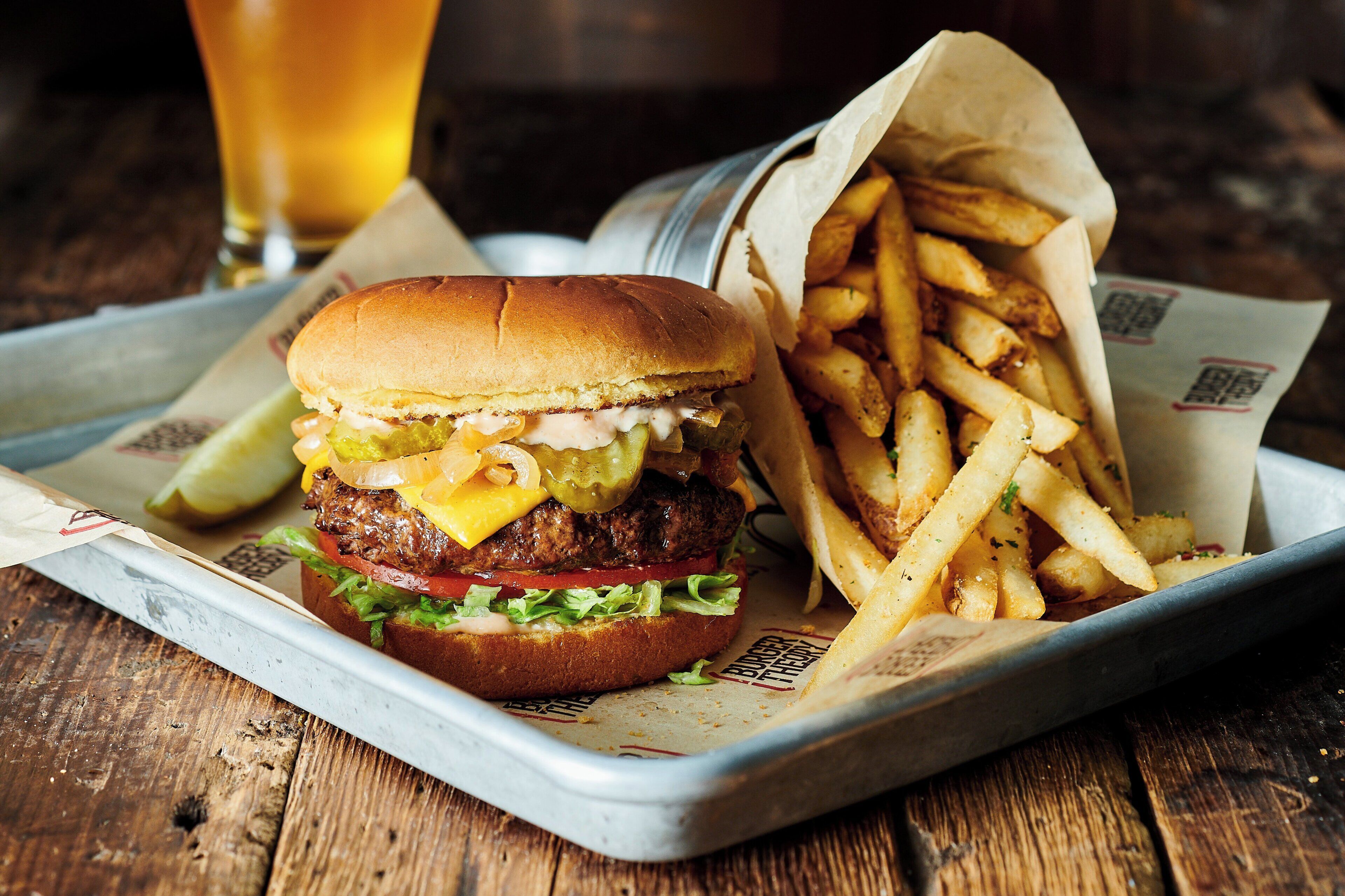 Un repas composé d’un hamburger et de frites, servi sur un plateau.