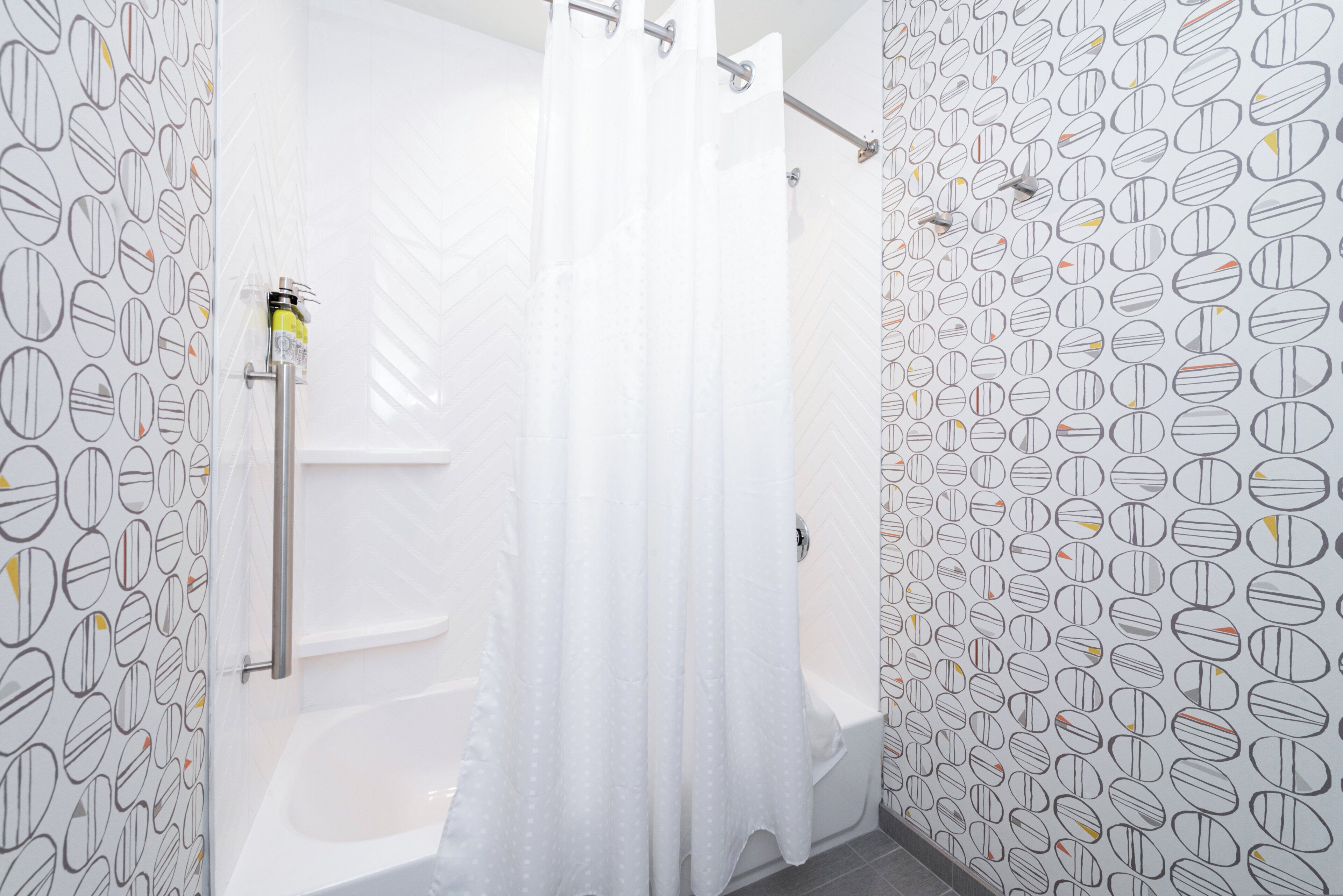 A bathroom with a shower curtain, a bathtub, and a toilet.