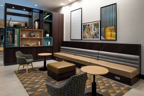Un área de descanso moderna con sofá, sillones y una mesita de centro.