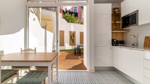 Una cocina moderna con armarios blancos, microondas integrado y encimera de madera.