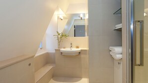 Uma casa de banho moderna com banheira, lavatório e zona de duche.