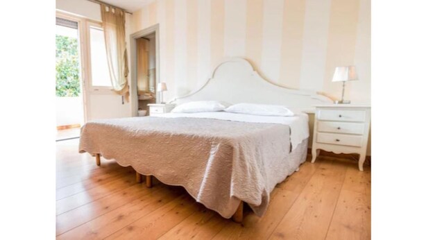 Ein Schlafzimmer mit Bett, Nachttischen und einem Fenster.