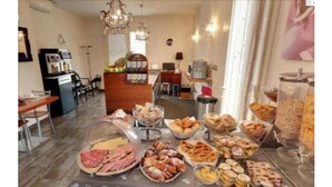 Ein Essbereich mit verschiedenen Speisen an einem Buffet, darunter Früchte, Gebäck und Sandwiches.
