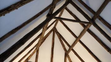 A vaulted ceiling with exposed wooden beams and a sculpture.