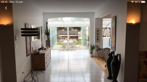 A spacious hallway with a glass door leading to an outdoor patio area. - Au 120 (Albi)