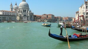 A gondola on a canal with a historic building in the background. - Al Ponte B&B (Padova)