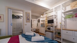 Une chambre d’hôtel équipée d’un lit, d’un bureau, d’une douche et d’une armoire.