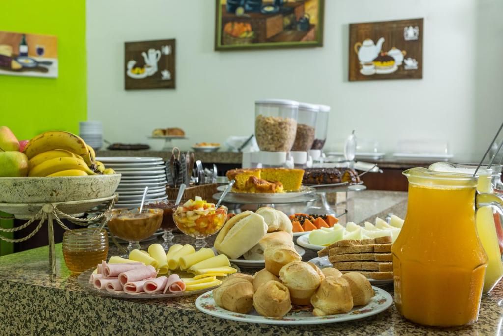 A breakfast buffet with various food items and a pitcher of orange juice.
