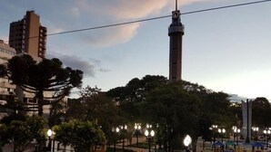 Un parque con una torre alta, árboles y un área de juegos.