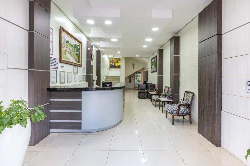A reception area with a curved counter, seating, and framed artwork on the walls.