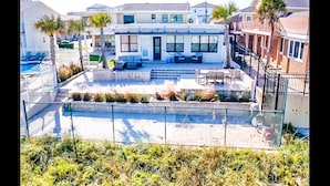 A residential building with a patio area, a swimming pool, and a small garden.
