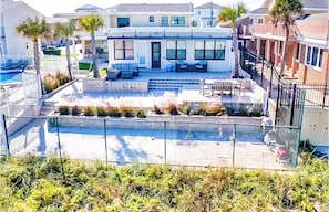 A residential building with a patio area, a swimming pool, and a small garden.