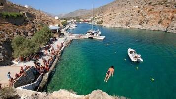 A coastal area with clear water, boats, and a rocky landscape.