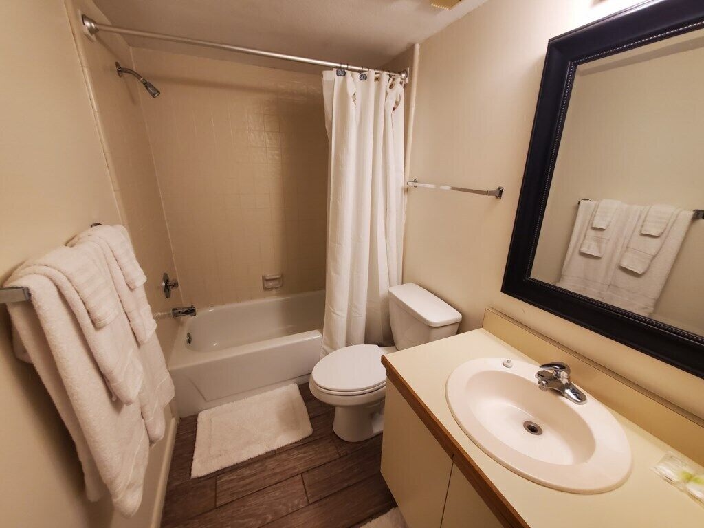 A bathroom with a bathtub, toilet, and sink.