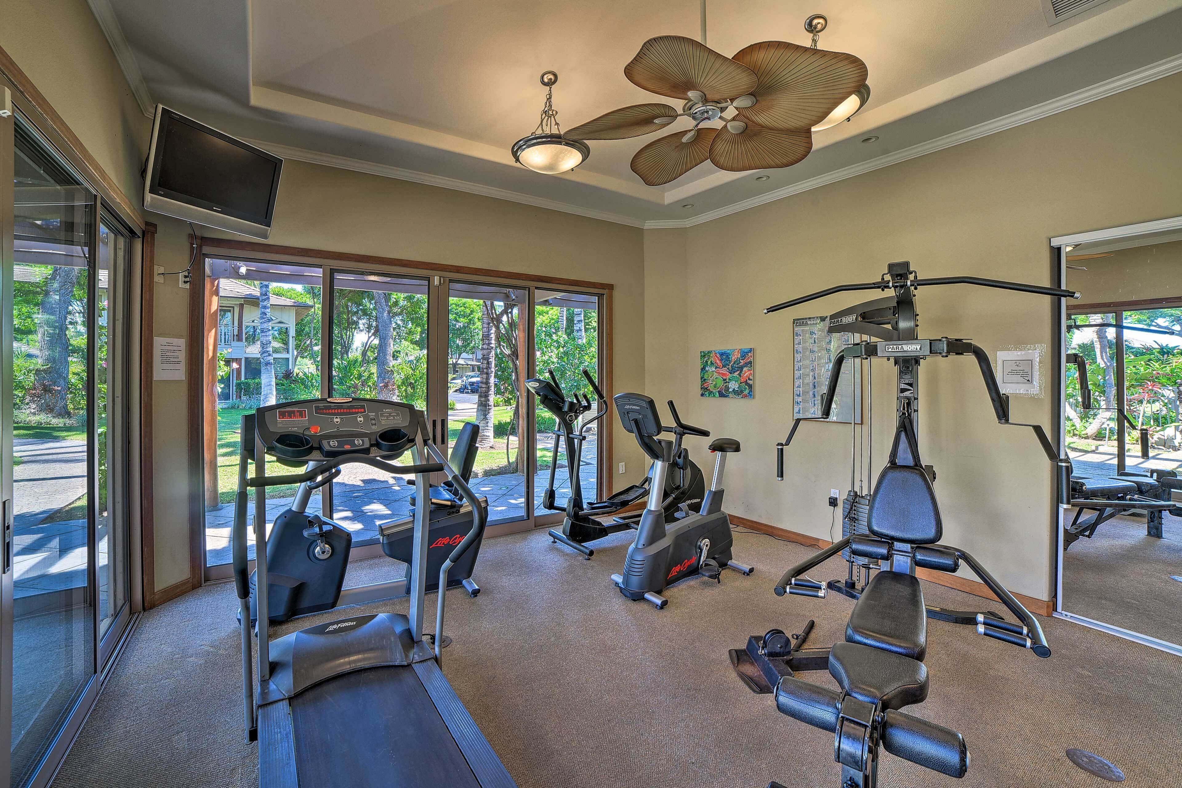 A gym with treadmills, elliptical machines, and a weight bench.