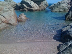 A rocky beach with clear shallow water.