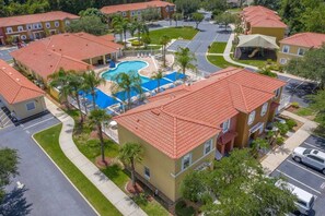 A residential area with multiple two-story buildings, a swimming pool, and a parking lot. - Family 4BR Pool  Near Disney (Kissimmee)