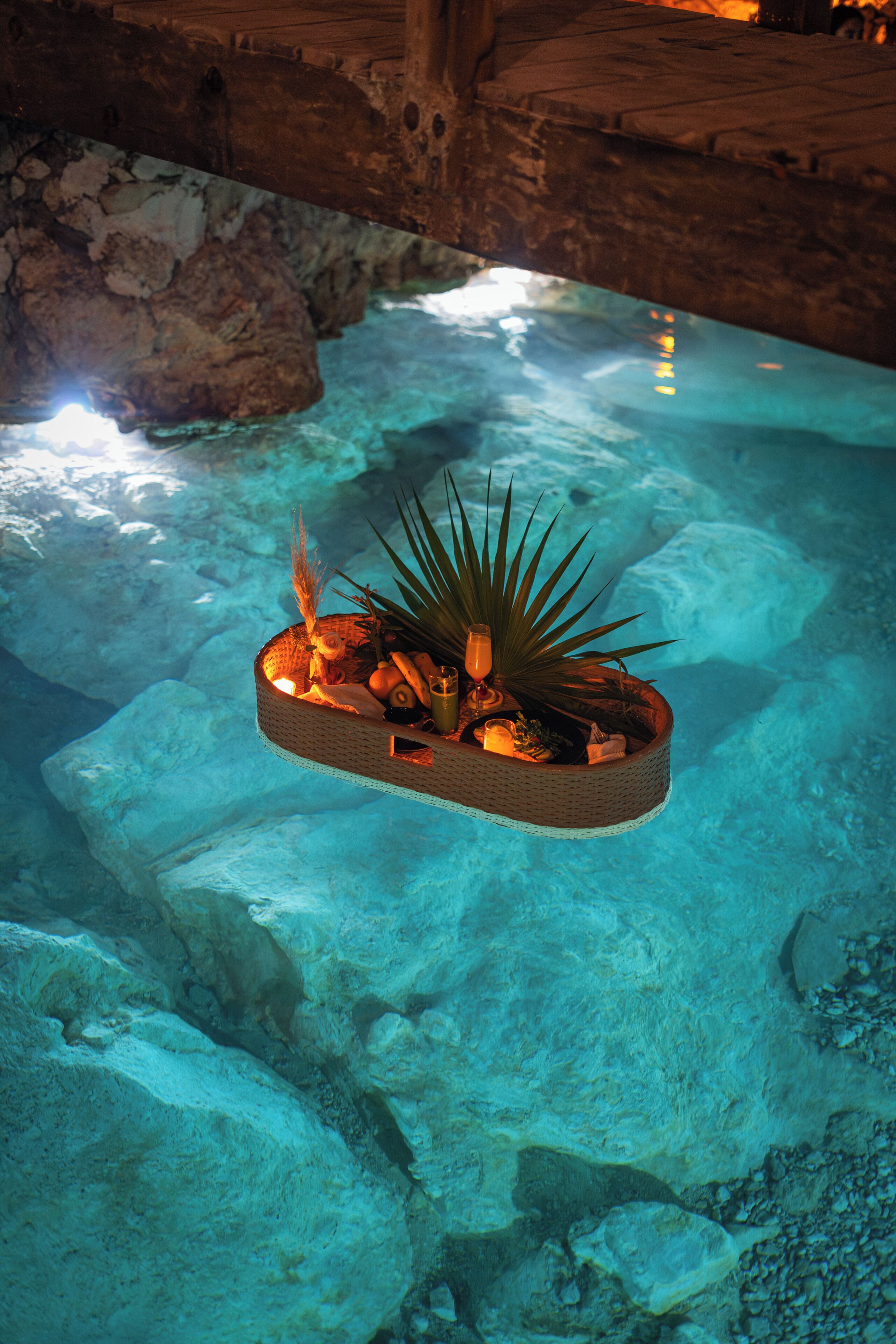 Una piscina submarina con un macetero flotante que contiene plantas y elementos decorativos.