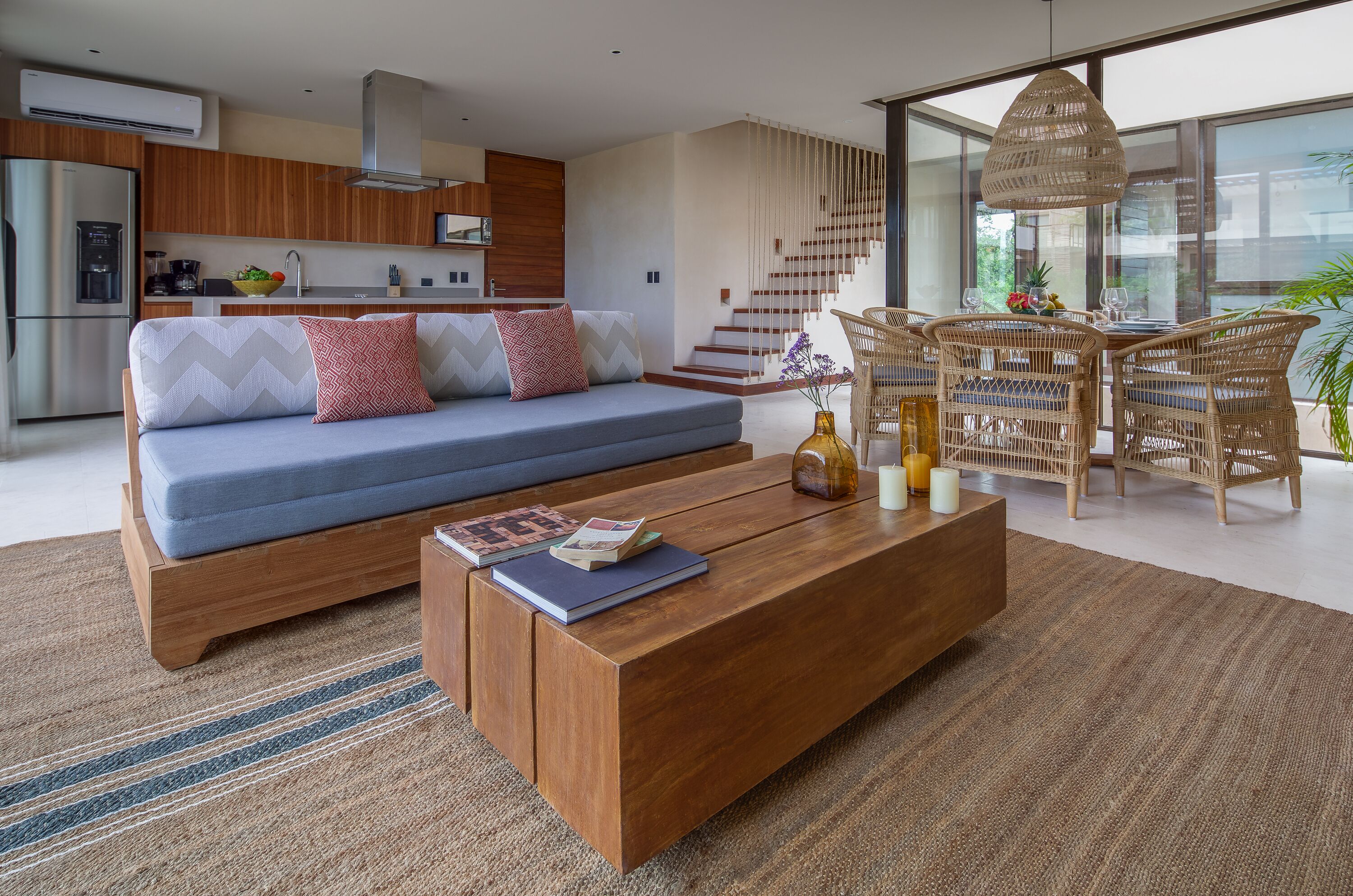 A modern living room with a sofa, coffee table, and wicker chairs.
