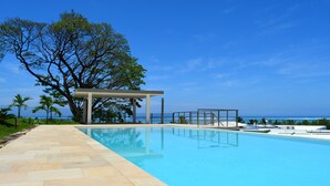 Un ciel d’un bleu éclatant, une piscine, une pergola et une vue sur l’océan.