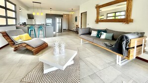 Un salon moderne avec un canapé, une table basse et un coin repas doté d’un bar.