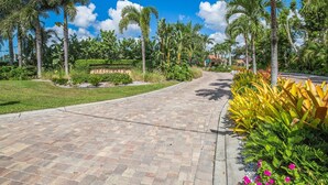 Un chemin pavé mène à un bâtiment sur lequel est apposée une enseigne indiquant « Beachwalk ».