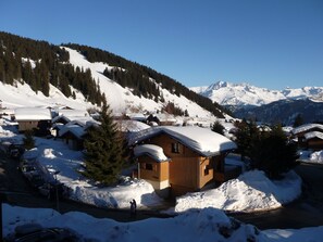 A snow-covered mountain village with wooden cabins and a clear view of snow-capped mountains. - Savoie, Col des Saisies, Apartment for rent (Hauteluce)