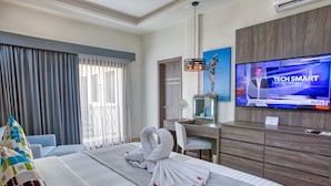 A hotel room with a bed, a desk, a television, and a mirror. - Casa Nicole Boutique Hotel (Puerto Vallarta)