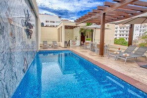 Piscine extérieure, parasols de plage, chaises longues